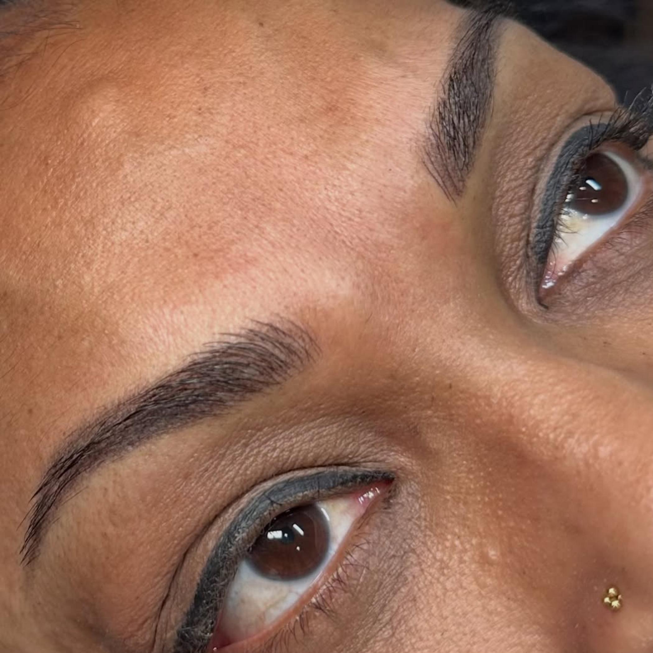 brow tattoo procedure with artist working