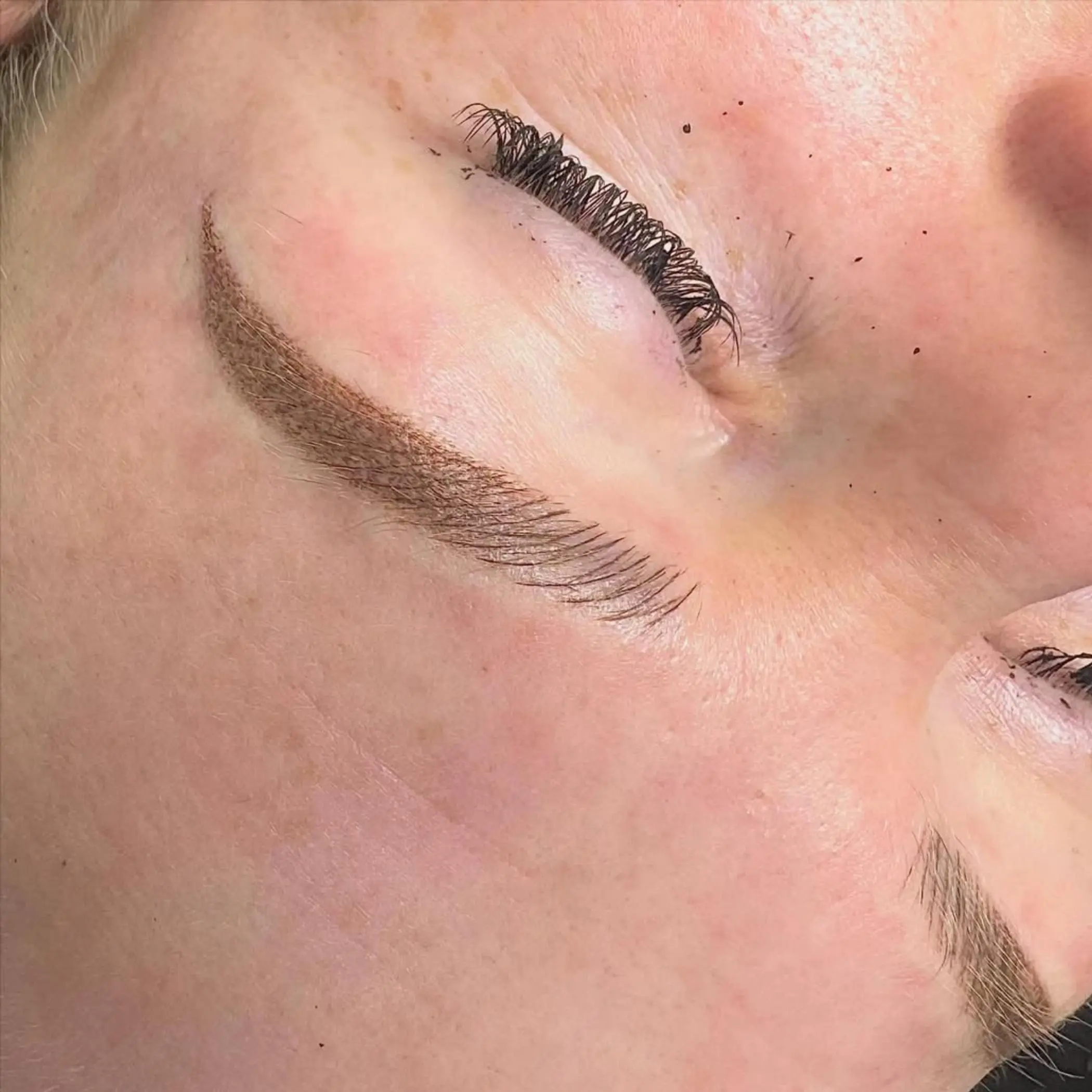 cosmetic tattoo artist applying brows
