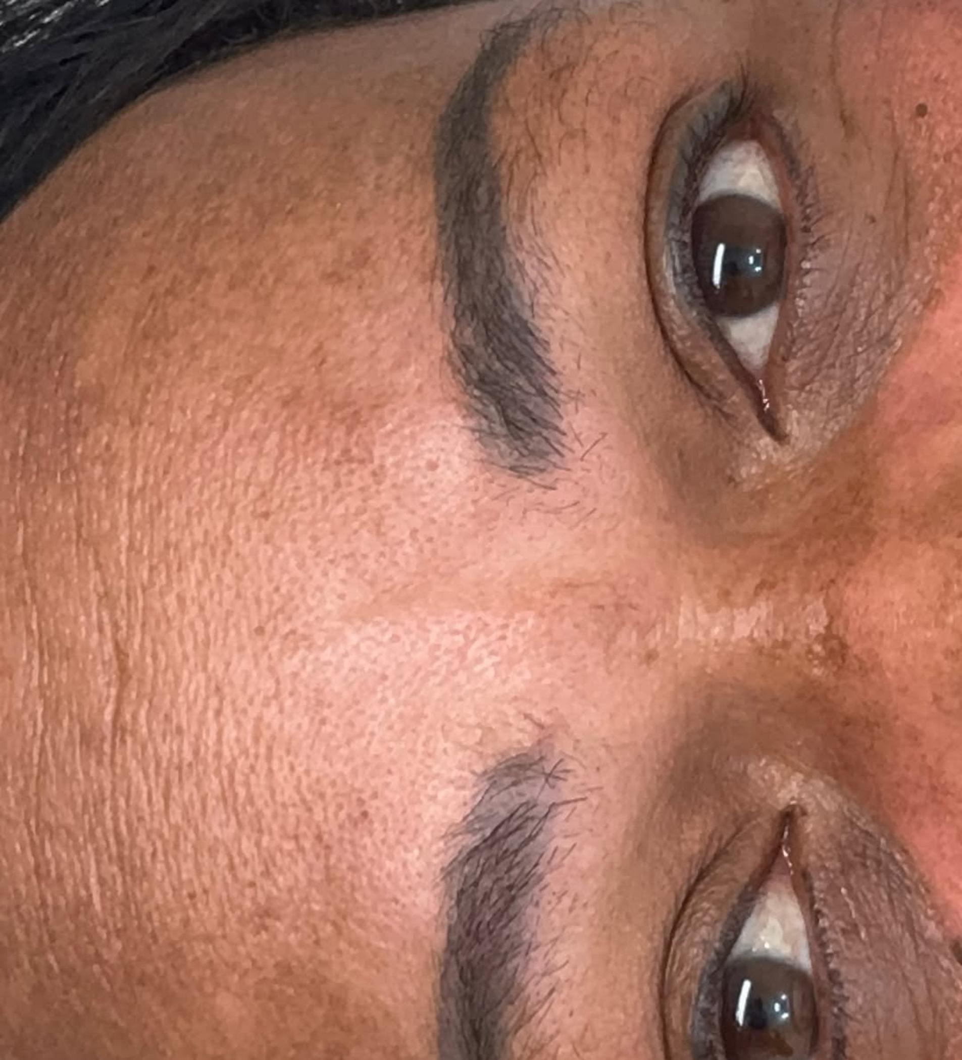 technician shaping eyebrows with stencil